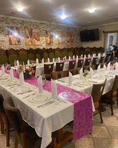 uma sala de conferências com mesas brancas e cadeiras com toalha de mesa roxa em Penzión ZOO Pod Hrešnou em Kavečany
