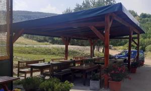 a pavilion with tables and benches and a blue roof at Penzión ZOO Pod Hrešnou in Kavečany