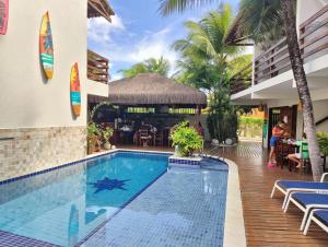 a swimming pool in a resort with a restaurant at Pousada Waikiki Boutique in Pipa