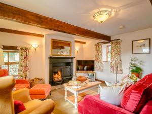 a living room with orange furniture and a fireplace at 2 bed in Ramsgill 89165 in Bouthwaite