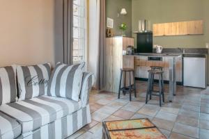 Il comprend un salon avec un canapé et une cuisine. dans l'établissement La Roseraie Hôtel Restaurant, à Montignac