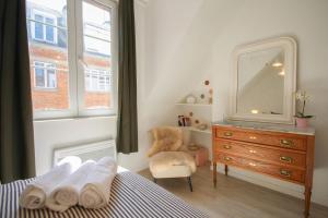 a bedroom with a dresser and a mirror and a chair at Lille Grand Place - Hypercentre ! in Lille