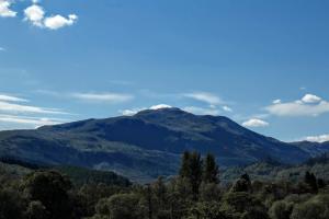 una montaña en la distancia con árboles en el primer plano en Callander Hostel en Callander