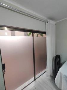 Schlafzimmer mit Glasschiebetür zum Balkon in der Unterkunft Alojamiento-frente al estadio 4 personas in Tarija