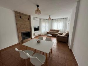 sala de estar con mesa blanca y sillas en Casa a la Vera de la Sierra, en Güéjar-Sierra