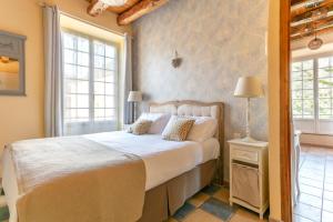 1 dormitorio con 1 cama y 2 ventanas en La Roseraie Hôtel Restaurant, en Montignac