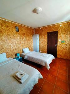 2 camas en una habitación con papel pintado de color naranja en I Ka Hale, en Vila Nova de Milfontes