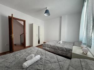 a bedroom with two beds with towels on them at Casa a la Vera de la Sierra in Güéjar-Sierra