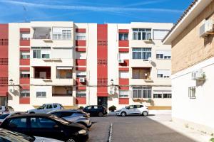 un estacionamiento con autos estacionados frente a un edificio en Apartamento Faro de Barbate, en Barbate