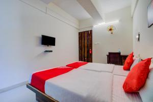 1 dormitorio con 1 cama blanca grande con almohadas rojas en Sairaj Lodge, en Méribel Village