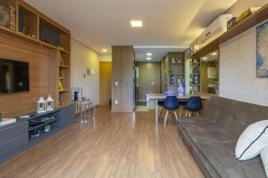 uma ampla sala de estar com um sofá e uma cozinha em Apartamento Novo e Moderno em Gramado em Gramado