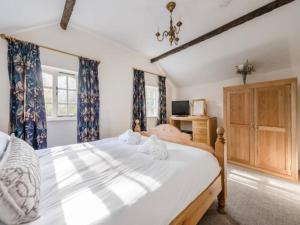 1 dormitorio con 1 cama grande y cortinas azules en Pass the Keys Shrewsbury Grade 2 Listed Black White Cottage, en Shrewsbury
