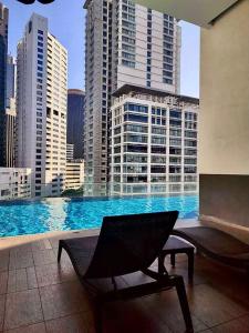 uma cadeira numa varanda com vista para a cidade em 1ceylon luxury pharoah apartment 2310 em Kuala Lumpur