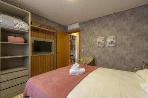um quarto com uma cama com uma toalha em Apartamento Novo e Moderno em Gramado em Gramado
