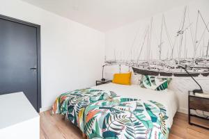 ein Schlafzimmer mit einem Bett und Segelbooten an der Wand in der Unterkunft L'Escale Paimpolaise 2 Étoiles - centre historique in Paimpol