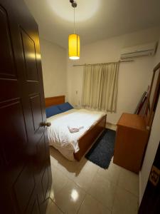 Schlafzimmer mit einem Bett, einem Tisch und einer Tür in der Unterkunft Cozy Townhouse, with back yard (98) in Sheikh Zayed