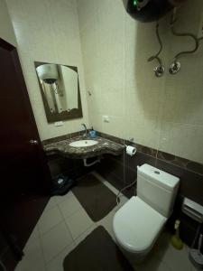 a bathroom with a white toilet and a sink at Cozy Townhouse, with back yard (98) in Sheikh Zayed