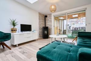 a living room with a green couch and a tv at 3 bedroom house with garden near St Maur tram in Marcq-en-Baroeul