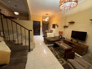 a living room with a couch and a tv at Cozy Townhouse, with back yard (98) in Sheikh Zayed