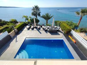 a swimming pool with a view of the ocean at Villa Sunrise first line in Coral Bay in Coral Bay