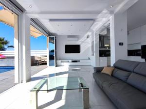 a living room with a couch and a glass table at Villa Sunrise first line in Coral Bay in Coral Bay
