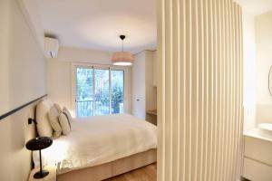 um quarto com uma cama branca e uma janela em Nice Signature Mont Alban em Nice