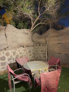 a table and chairs with a table and a tree at Cozy Townhouse, with back yard (98) in Sheikh Zayed