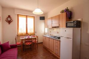 eine Küche mit einem weißen Kühlschrank und einem Tisch in der Unterkunft Appartamento PE in Follonica