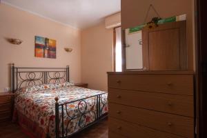 ein Schlafzimmer mit einem Bett und eine Kommode mit einem Spiegel in der Unterkunft Appartamento PE in Follonica