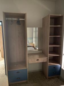 1 dormitorio con armario de madera y espejo en DieStrandwolf Sea View Self Catering en Hentiesbaai