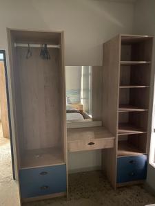 un armadio in legno con specchio in una camera da letto di DieStrandwolf Sea View Self Catering a Hentiesbaai