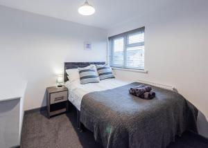 een slaapkamer met een bed met een teddybeer erop bij High End Double Room with Own Bathroom Facilities in Bedford