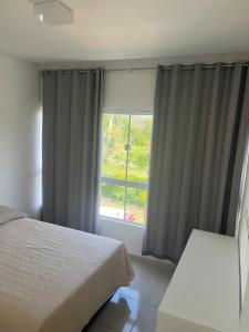 1 dormitorio con cama y ventana en Condomínio Villa Verde Triunfo en Triunfo