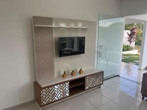 a living room with a tv on a wall at Condomínio Villa Verde Triunfo in Triunfo