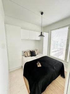 a bedroom with a bed with a black blanket on it at New 3-Bed Apartment & Free Garage parking & PS5 in Vantaa