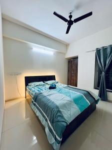 a bedroom with a bed with a ceiling fan at 2BHK Oasis in Prime Kharadi in Pune