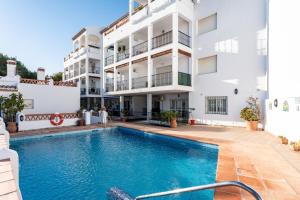 an apartment with a swimming pool in front of a building at Sierra Mar Penthouse in Mijas