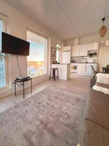 sala de estar con TV y cocina en New 3-Bed Apartment & Free Garage parking & PS5 en Vantaa