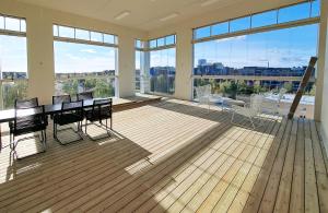 a large room with a table and chairs and windows at New 3-Bed Apartment & Free Garage parking in Vantaa