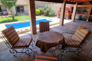 a patio with a table and chairs and a pool at Inolvidable casa clásica in Las Heras
