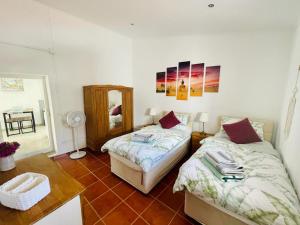 - une chambre avec 2 lits, une table et un miroir dans l'établissement Quinta Da Horta, à São Brás de Alportel 27 autres photos