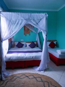 a bedroom with two beds with a canopy at Safari Park House in Arusha +182 photos
