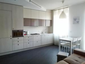een keuken met witte kasten en een tafel en een bank bij FM Lake in Como