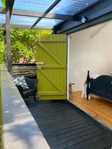 a green door on a deck with a bed at Boho Glamping in Wilderness