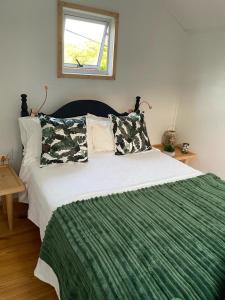 a bedroom with a large bed with a green blanket at Boho Glamping in Wilderness