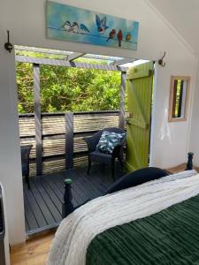Habitación con terraza con cama y silla en Boho Glamping, en Wilderness