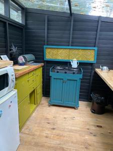 a kitchen with a blue stove and yellow cabinets at Boho Glamping in Wilderness