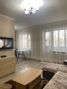 a living room with a tv and a table at 2кмн Квартира по проспекту Республики 8 in Astana