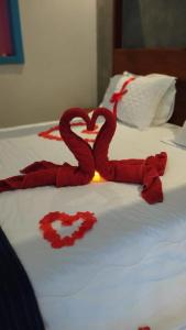 Dos serpientes rojas formando un corazón en una cama en Pousada Vila do Lago, en Capitólio