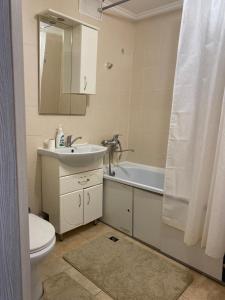 a bathroom with a sink and a toilet and a mirror at 2кмн Квартира по проспекту Республики 8 in Astana